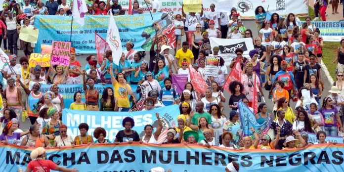mulheres em marcha, com cartazes na primeira marcha das mulheres negras em 2015.