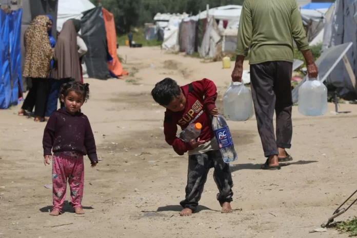 Crianças buscam água potável no campo de refugiados palestinos de Bureij, na região central da Faixa de Gaza, em 28 de abril de 2026