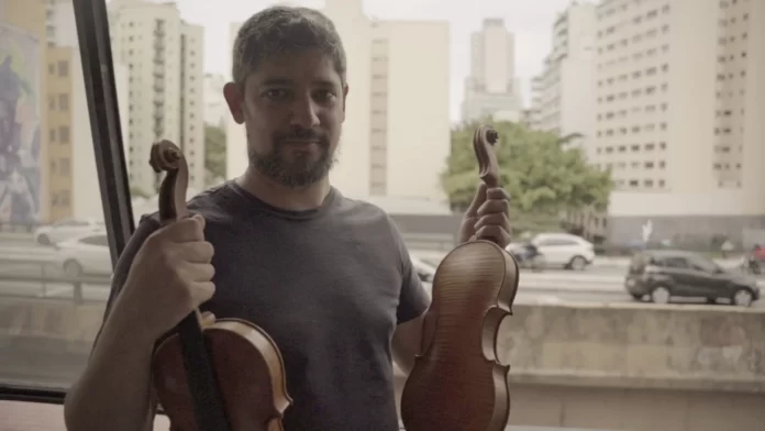 O luthier André Amaral em sua janela de frente para o minhocão
