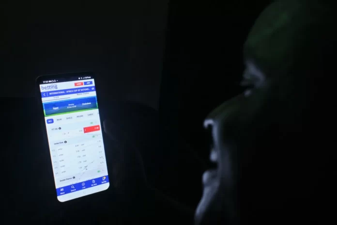 Pessoa utiliza aplicativo de apostas no celular; mercado cresce com forte presença no ambiente digital e publicidade constante