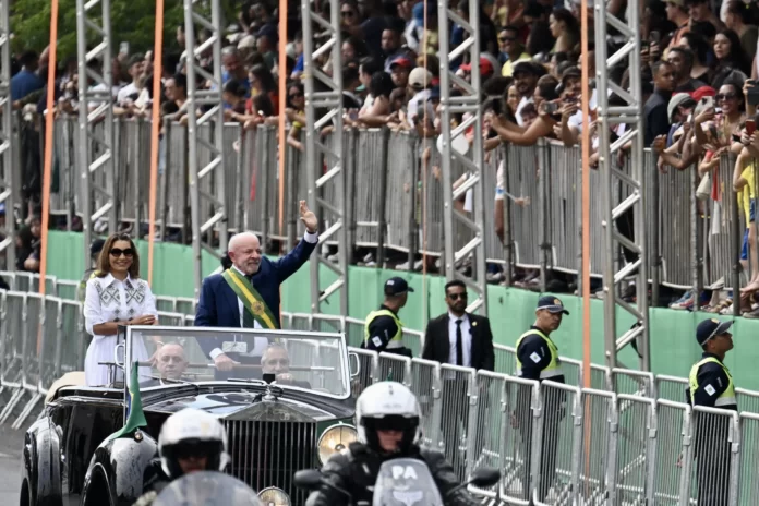 O presidente Luiz Inácio Lula da Silva acena ao lado da primeira-dama, Rosângela da Silva, durante o desfile militar das comemorações do Dia da Independência, em Brasília, em 7 de setembro de 2026.